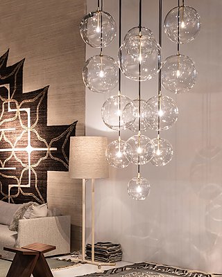 Eine Gruppe von großen, klaren Glaskugel-Pendelleuchten in einem stilvollen Wohnzimmer.