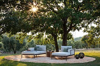Zwei Chaiselongues unter einem großen Baum.