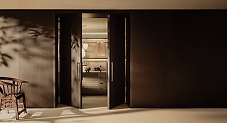 Ein offener, begehbarer Kleiderschrank, der durch zwei große Türen betreten wird.