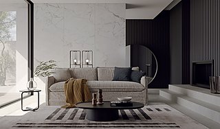 Ein beiges Sofa vor einer Wand aus weißem Marmor und schwarzen Holzlatten.