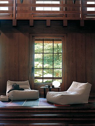 Zwei gemütliche, weiße Sitzsäcke vor einem großen Fenster in einem holzverkleideten Raum.