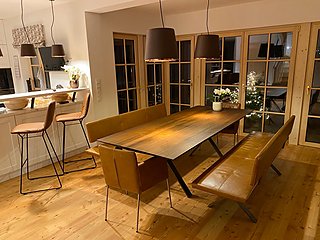 Großer Esstisch aus Räuchereiche mit Ledersitzbänken und Pendelleuchten im Landhaus.