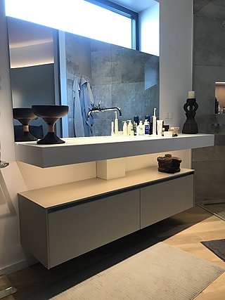 Weißer Hängewaschtisch mit integriertem Becken, Spiegel und offenem Ablagefach.