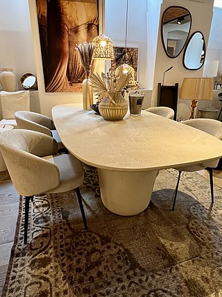 Vier Lema Bice Polsterstühle in Beige an einem ovalen Esstisch im Schauraum